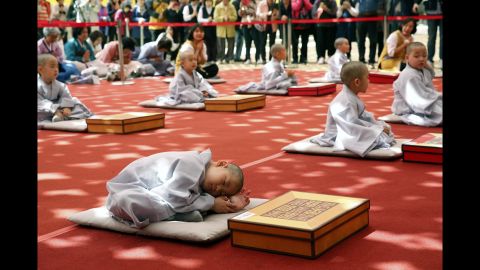 A boy rests after having his head shaved during a Buddhist ceremony in Seoul, South Korea, on Monday, April 22. 
