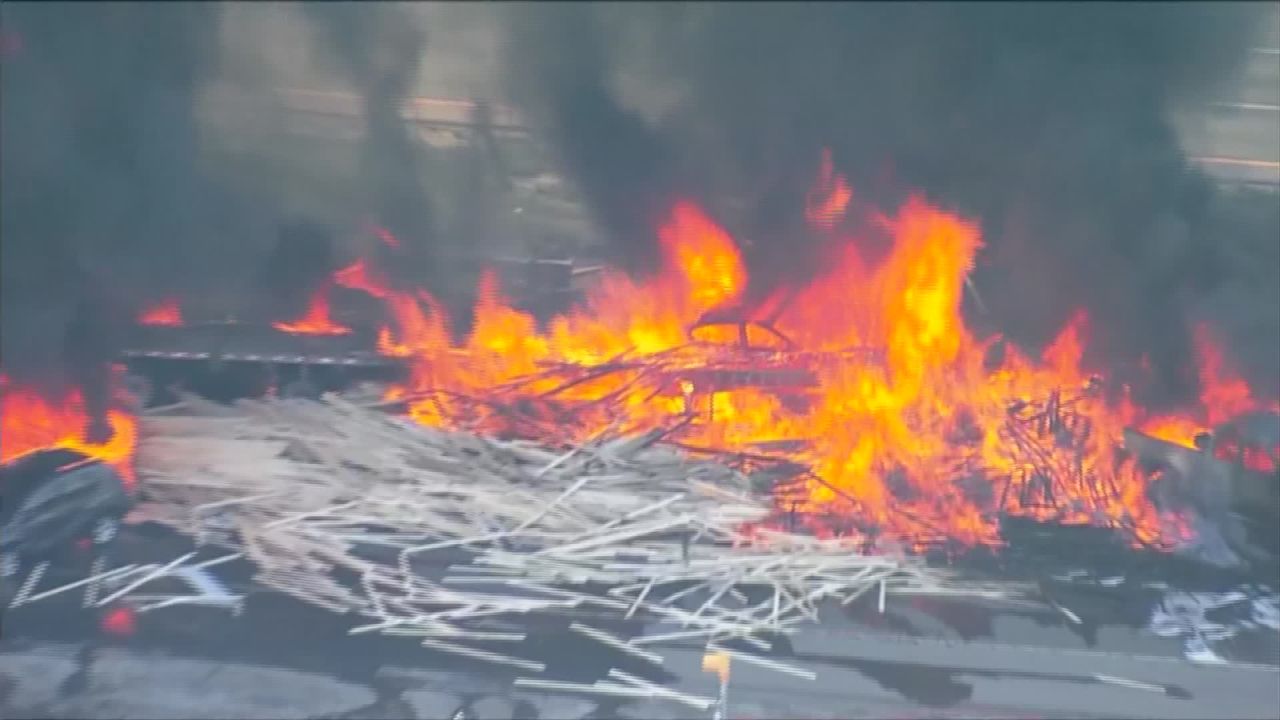 Video from the scene showed towering orange flames and piles of lumber scattered across the highway. 