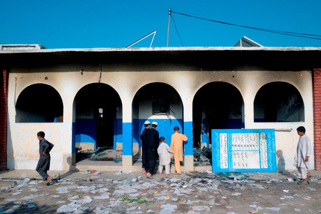 In this picture taken on Monday outside Peshawar, Pakistani children look at a damaged health center local torched by a mob following rumors related to  polio vaccinations.