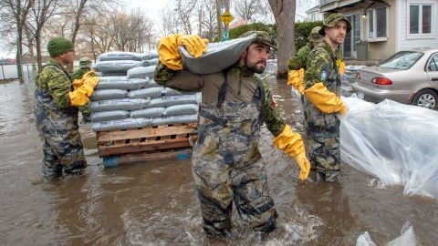 Canadian Forces personnel sandbag a house against floodwaters Thursday in Laval, Quebec.