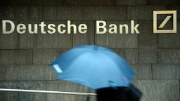A woman with a umbrella passes a logo of Deutsche Bank on January 29, 2013 in Frankfurt am Main, Germany. 