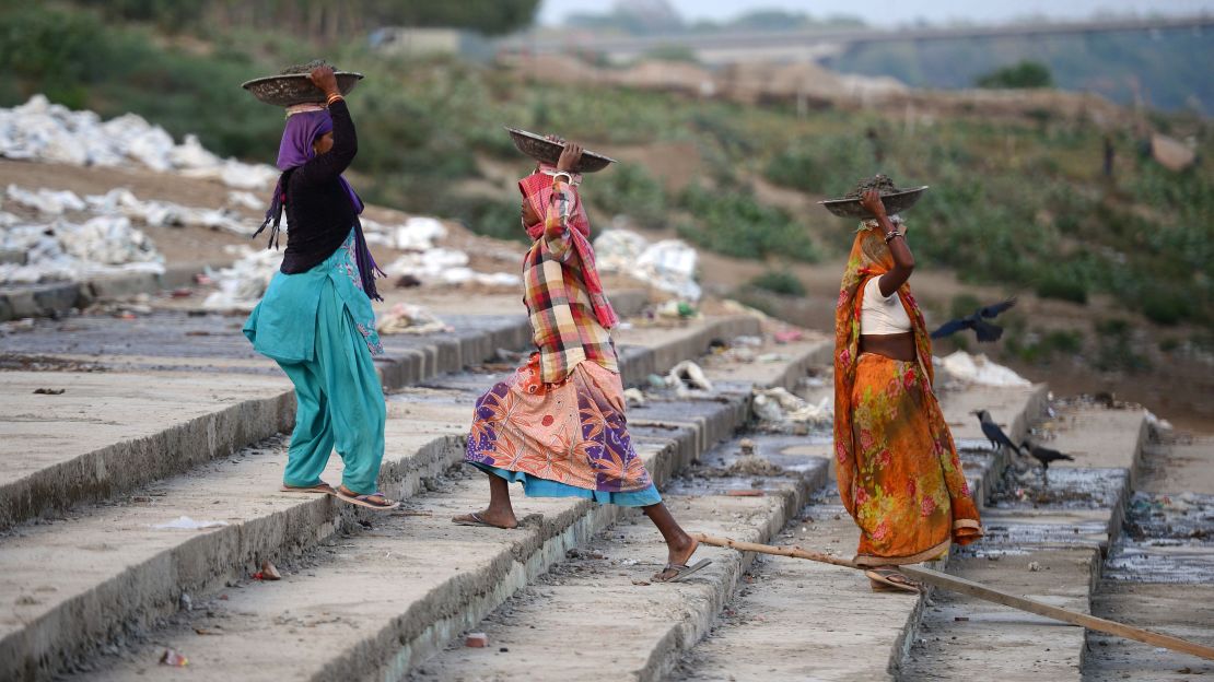 Indian women work at a construction site in Prayagraj in the state of Uttar Pradesh. 