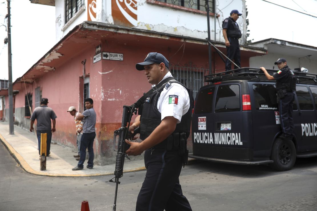Municipal police stand guard at a forensic office where the bodies of the Mixtla de Altamirano mayor, her husband and her driver were taken after a drive-by shooting.