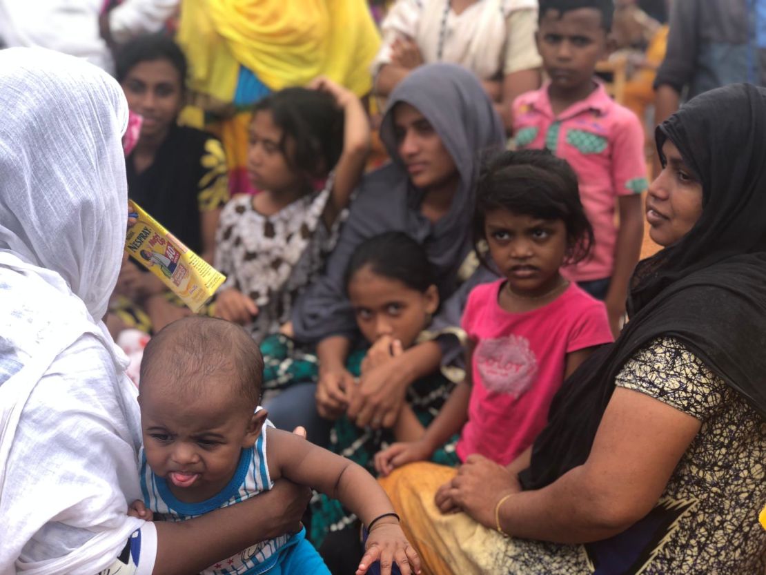 Women and children wait at a school after being evacuated from near the shootout site.