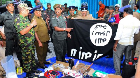 Security personnel display seized items, including an ISIS flag, in Friday's operations.