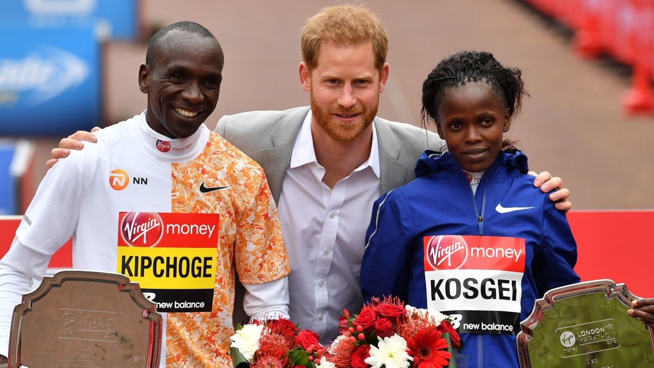 Prince Harry poses with the winners of the men's and women's race after presenting them with their medals.