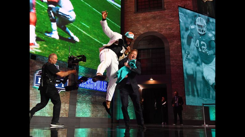 Clemson's Christian Wilkins celebrates with NFL commissioner Roger Goodell after he was selected as the number thirteen overall pick to the Miami Dolphins in the first round of the 2019 NFL Draft in Downtown Nashville on Thursday, April 25.