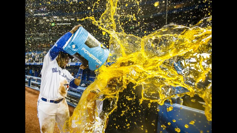 Toronto Blue Jays' Vladimir Guerrero Jr., left, douses teammate Brandon Drury after Drury hit a walk-off home run to defeat the Oakland Athletics during the ninth inning of the game in Toronto on Friday, April 26.