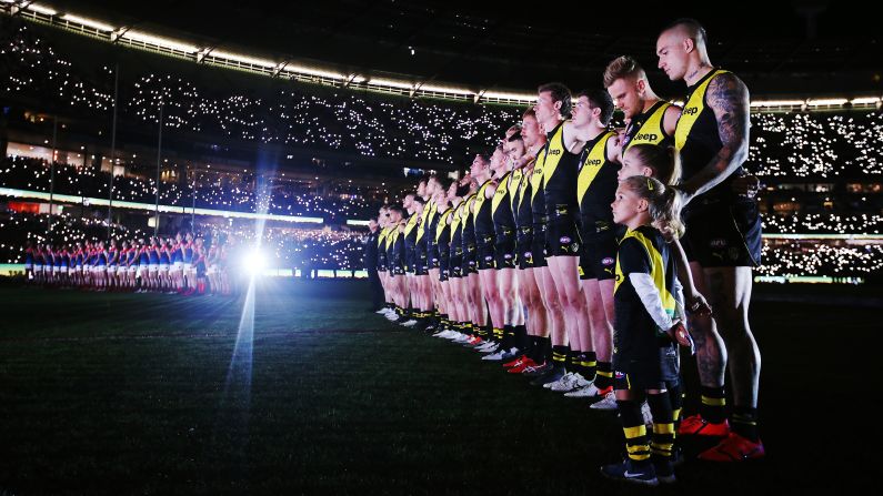 Demons and Tigers players stand in line for a minute's silence for the ANZAC observance during the round 6 AFL match between Richmond and Melbourne at Melbourne Cricket Ground on Wednesday, April 24.