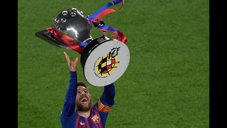 Barcelona's forward Lionel Messi raises the La Liga trophy as he celebrates becoming La Liga champions after winning the Spanish League football match between FC Barcelona and Levante UD at the Camp Nou stadium in Barcelona on Saturday, April 27.
