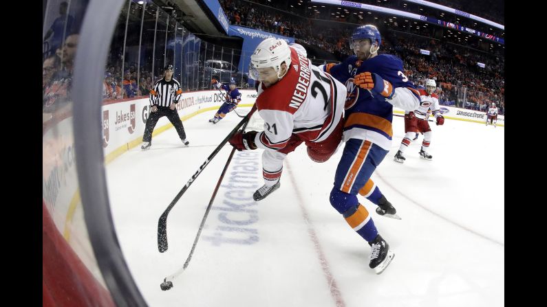 Carolina Hurricanes right wing Nino Niederreiter, left, of Switzerland, goes airborne while taking a hit from New York Islanders defenseman Adam Pelech during the first period of Game One of an NHL hockey second-round playoff series in New York on Friday, April 26.