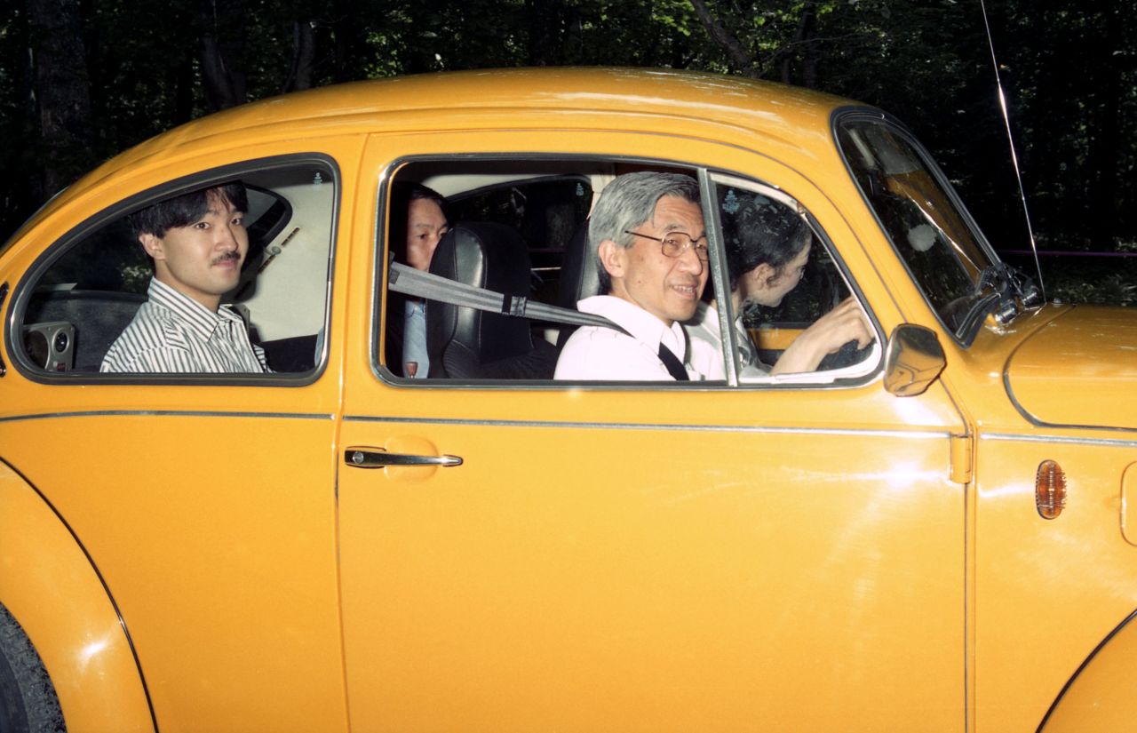 Akihito drives to an imperial villa in 1989. Michiko is in the front passenger seat. Behind Akihito is his son Fumihito.