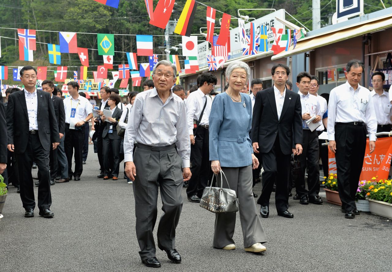 Akihito and Michiko tour shops in Minamisanriku, Japan, in July 2014. They offered encouragement to store owners who were affected by the earthquake and tsunami in 2011.
