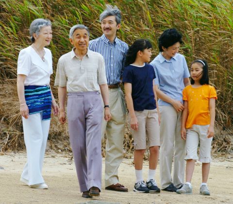 Akihito and Michiko walk on a beach in Shimoda, Japan, in 2004. Joining them were their son Fumihito and Fumihito's family: wife Kiko and daughters Mako and Kako.