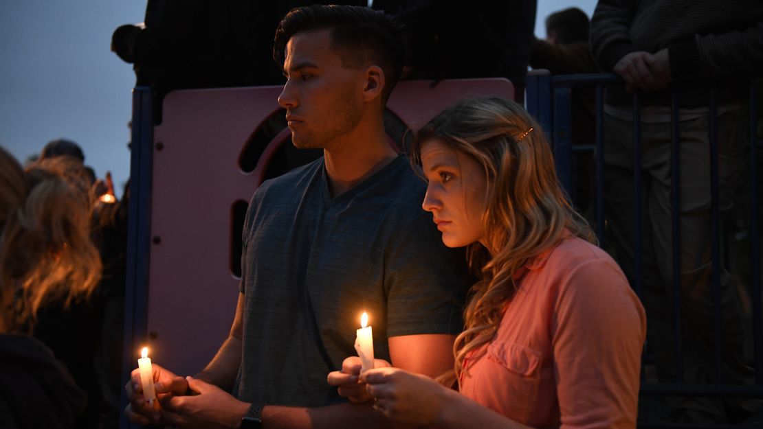 Attendees hold candles during a vigil Sunday night.