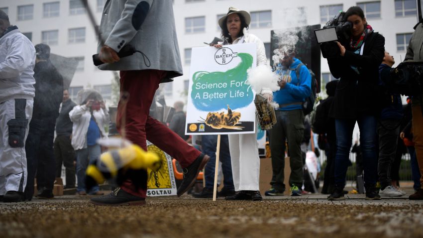 Shareholders walk past protesters over dead bees during a demonstration outside the World Conference centre where the annual general meeting of German chemicals giant Bayer takes place on April 26, 2019 in Bonn, western Germany. - Bayer saw its net profit decline by 36% year-on-year in the first quarter, due to the costs associated with last year's acquisition of Monsanto, the group announced during its annual general meeting of shareholders. (Photo by INA FASSBENDER / AFP)        (Photo credit should read INA FASSBENDER/AFP/Getty Images)