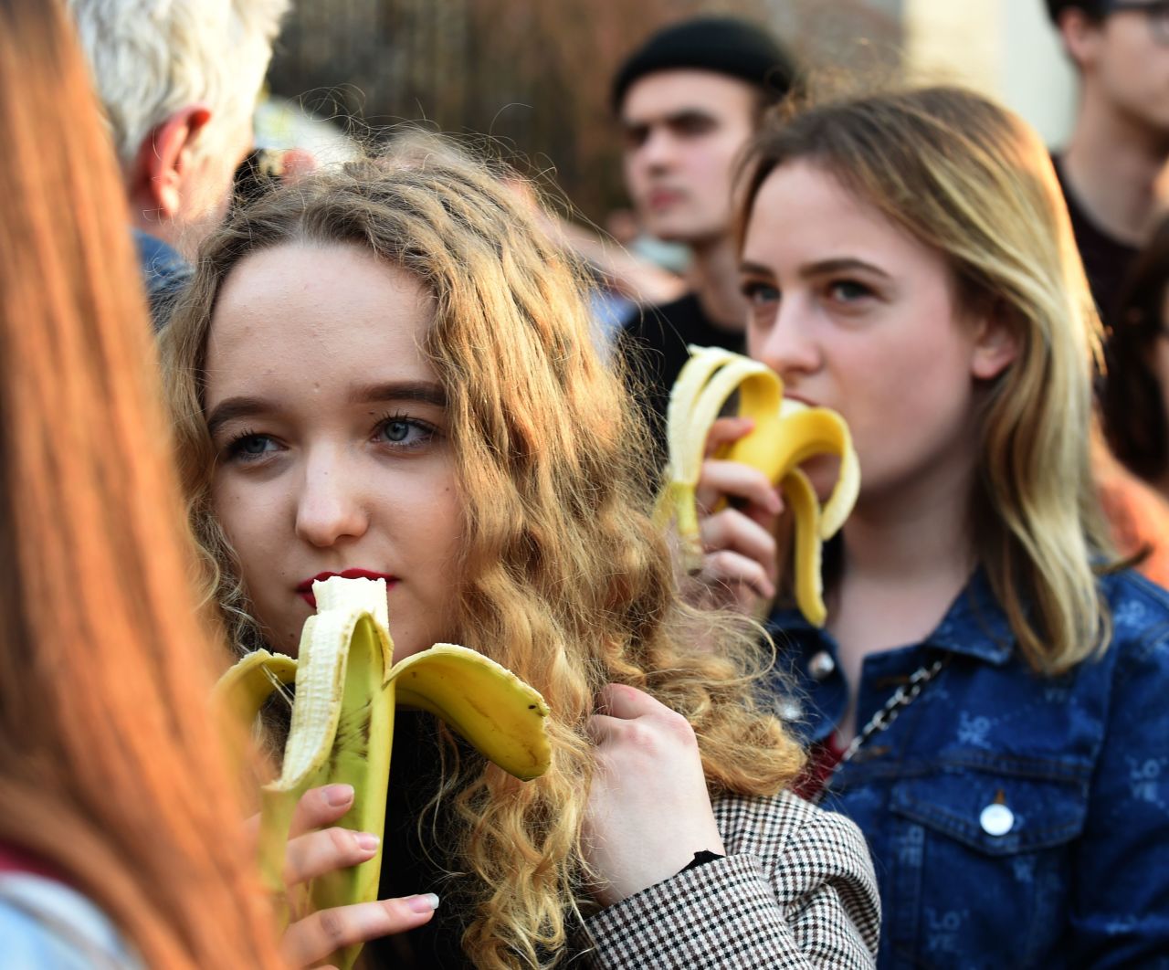 People with bananas demonstrate outside the National Museum of Warsaw on April 29, 2019, to protest against censorship, after authorities removed an artwork at the museum presenting a woman eating a banana.
