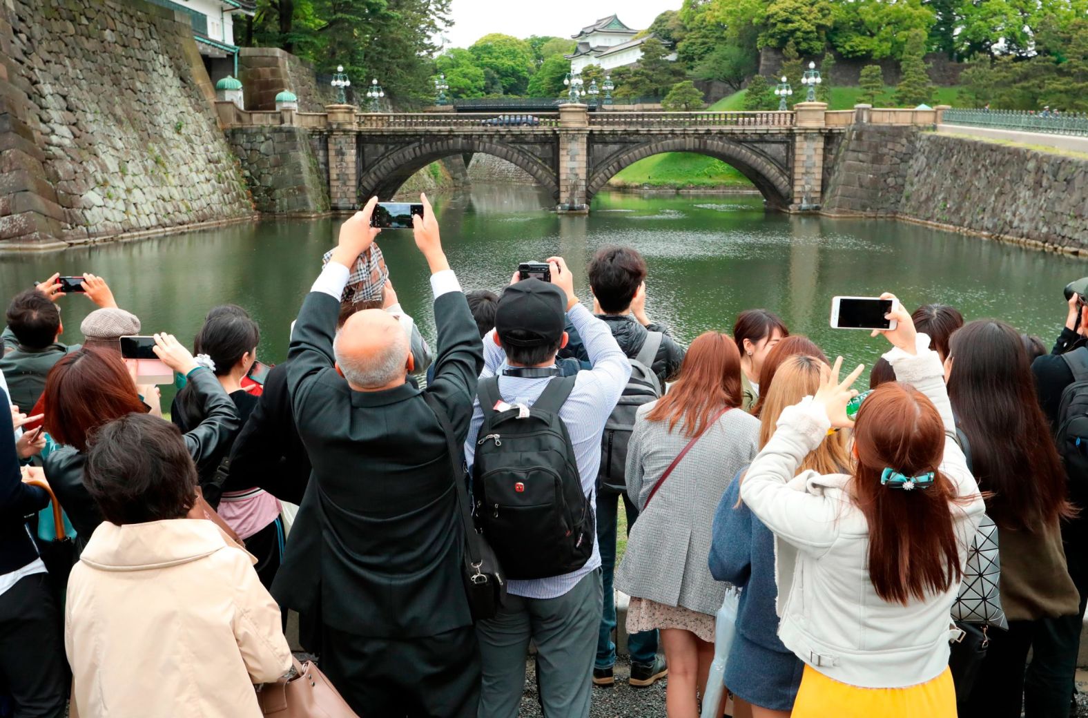 People take photos of the famous double bridge at the Imperial Palace compound.