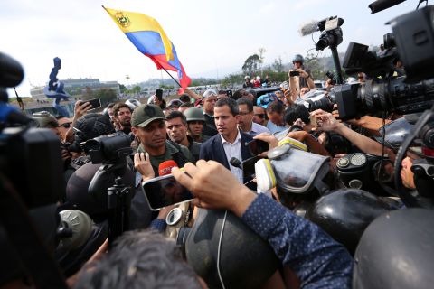 Guaido, center, appears before reporters and photographers outside the airbase in Caracas. To his right is opposition activist Leopoldo Lopez, who is essentially his predecessor.