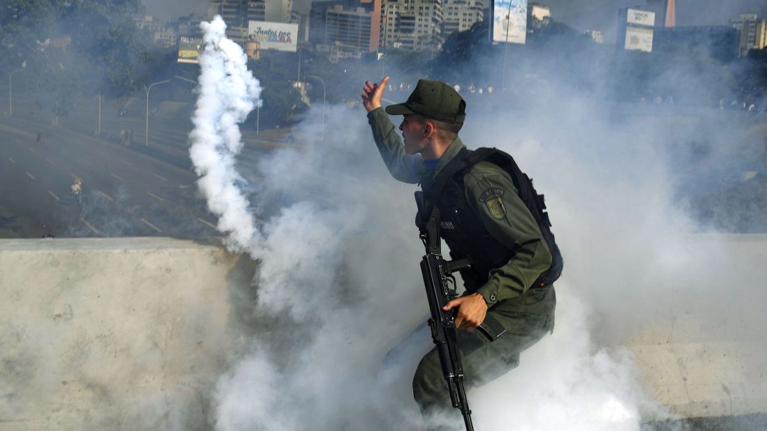 A pro-Guaido military member throws a tear-gas canister during a confrontation with guards loyal to Maduro.