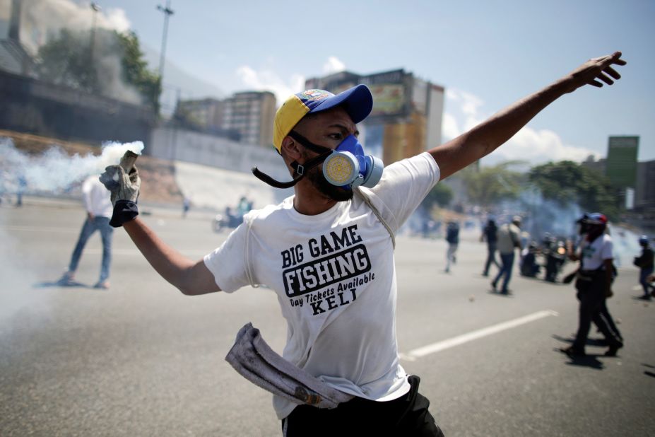 An opposition demonstrator throws back a tear-gas canister.