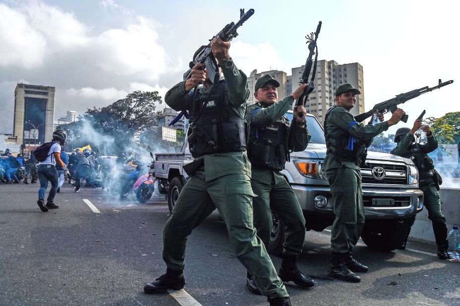 Members of the military who support Guaido fire into the air to repel forces loyal to Maduro on Tuesday, April 30. The Maduro forces were trying to disperse a demonstration near the La Carlota base.