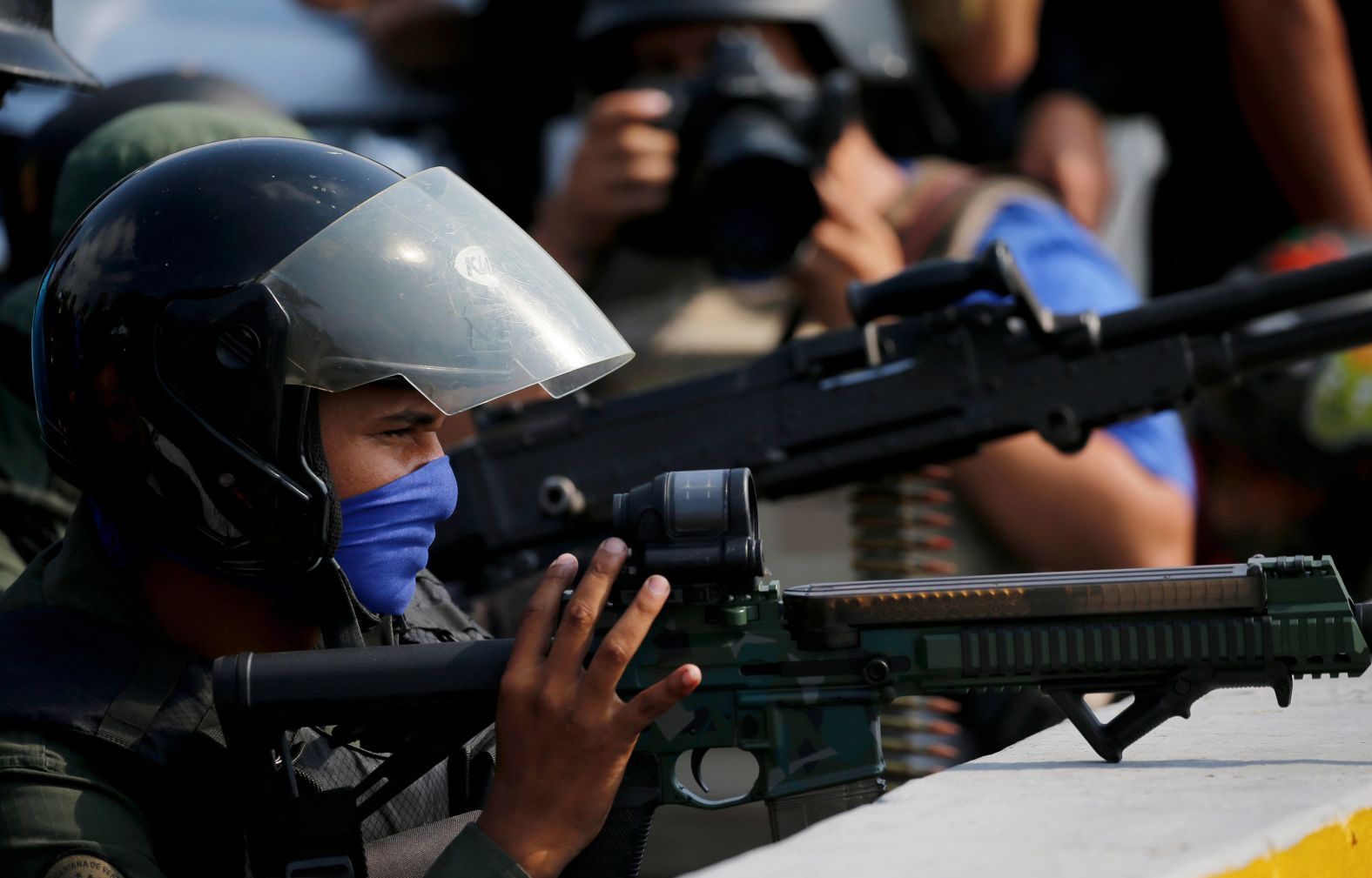 Soldiers who oppose Maduro's government take cover on an overpass.