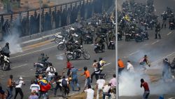 Opponents to Venezuela's President Nicolas Maduro confront loyalist Bolivarian National Guard troops firing tear gas at them, outside La Carlota military airbase in Caracas, Venezuela, Tuesday, April 30, 2019. Venezuelan opposition leader Juan Guaidó took to the streets with activist Leopoldo Lopez and a small contingent of heavily armed troops early Tuesday in a bold and risky call for the military to rise up and oust socialist leader Nicolas Maduro. (AP Photo/Fernando Llano)