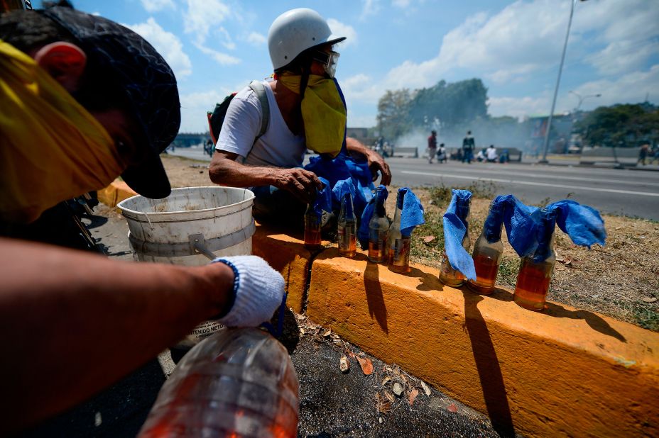 Opposition demonstrators prepare Molotov cocktails during clashes with soldiers loyal to Maduro.