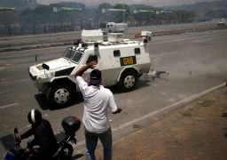 An opposition demonstrator is struck by a Venezuelan National Guard vehicle on a street near the "La Carlota" airbase.