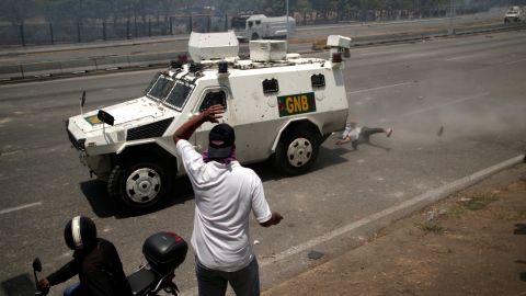 An opposition demonstrator is struck by a Venezuelan National Guard vehicle on a street near the "La Carlota" airbase.