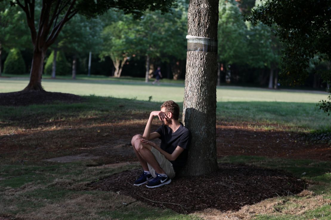 A student sits under a tree after the shooting on the Charlotte campus. 