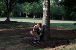 A student sits under a tree after Tuesday's shooting at the University of North Carolina at Charlotte. 