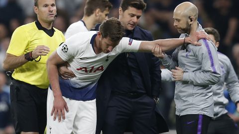 Tottenham Hotspur manager Mauricio Pochettino helps Jan Vertonghen (C) as he leaves the pitch injured.