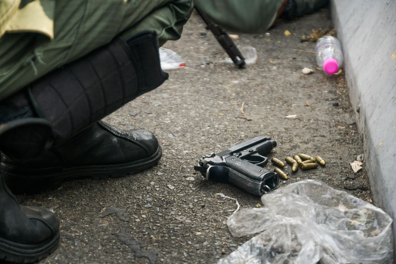 A handgun belonging to a soldier is seen on the ground, along with bullets.