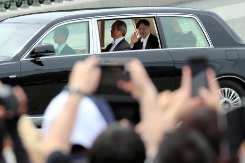 Naruhito waves to well-wishers.