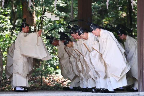 Shinto priests recite religious passages before entering the Meiji Shrine's main building for a ceremony on Wednesday. The ceremony reported the new emperor's enthronement to the royal family's ancestors.