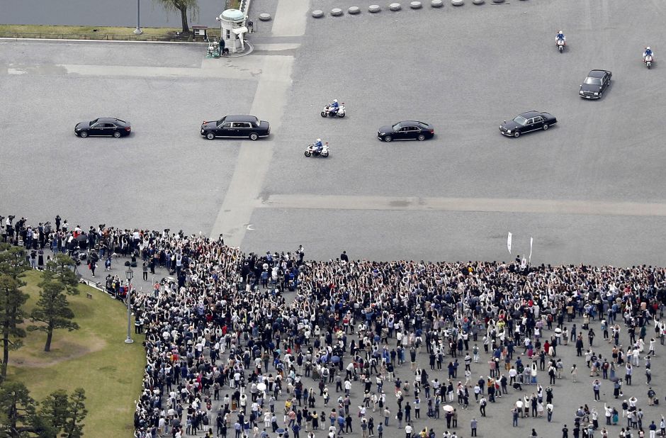 Naruhito's motorcade drives past crowds of well-wishers.