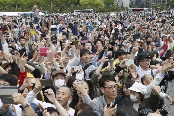 People gather to see the new Emperor and take photos.