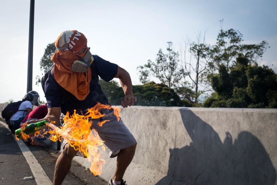 A demonstrator throws a Molotov cocktail at National Guard security forces near the La Carlota airbase on April 30.