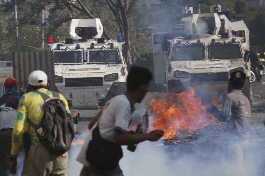 Maduro opponents face off with Maduro loyalists in armored vehicles.