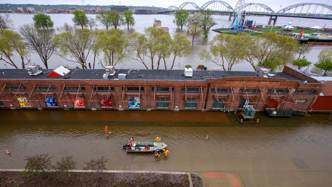 Davenport firefighters walk a rescue boat down West River Drive along the freight house in Davenport on Tuesday, April 30, 2019.