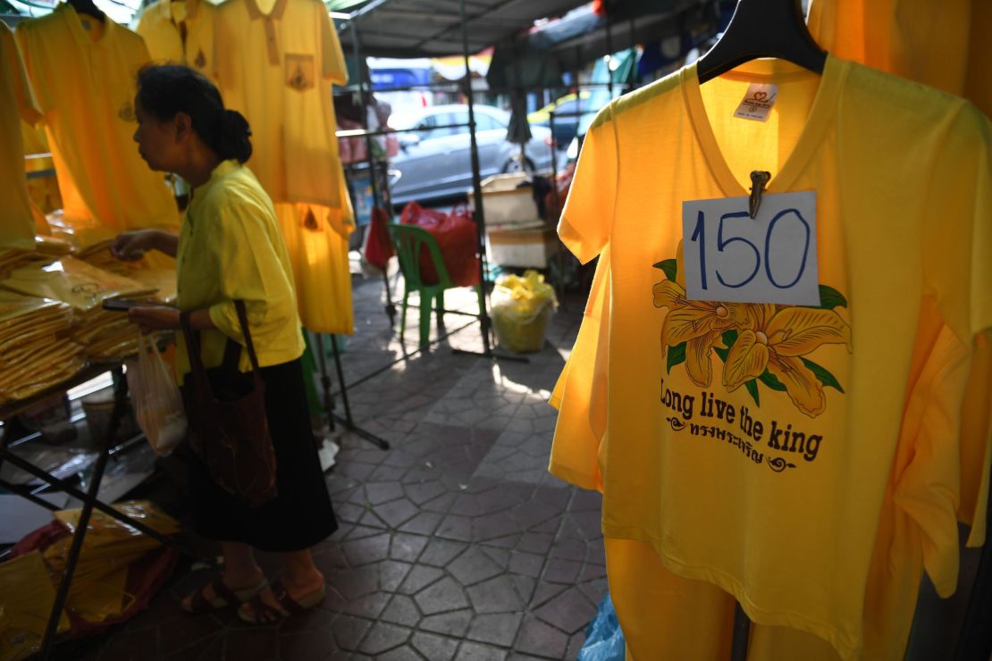 A woman browses through yellow shirts in honor of Thailand's King Maha Vajiralongkorn being sold in Bangkok on April 25, 2019, ahead of his royal coronation. 