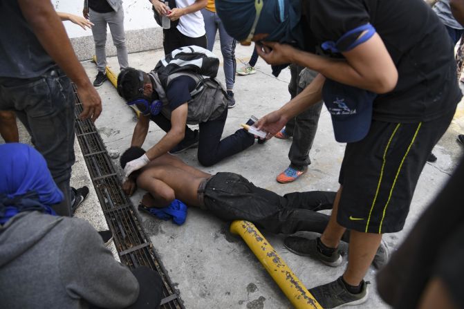 An anti-government protester is assisted during clashes with security forces on May 1.