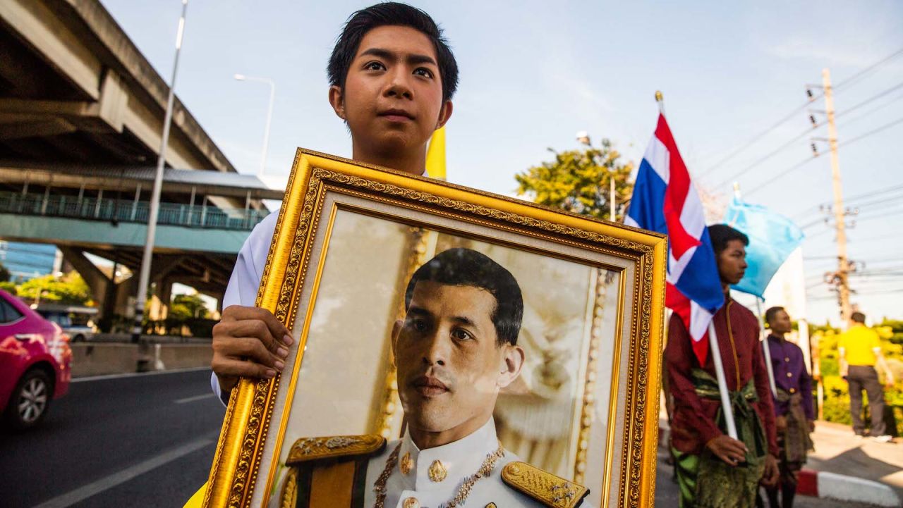 A young Thai man holds a portrait of King Rama X on May 1, 2019 in Bangkok.