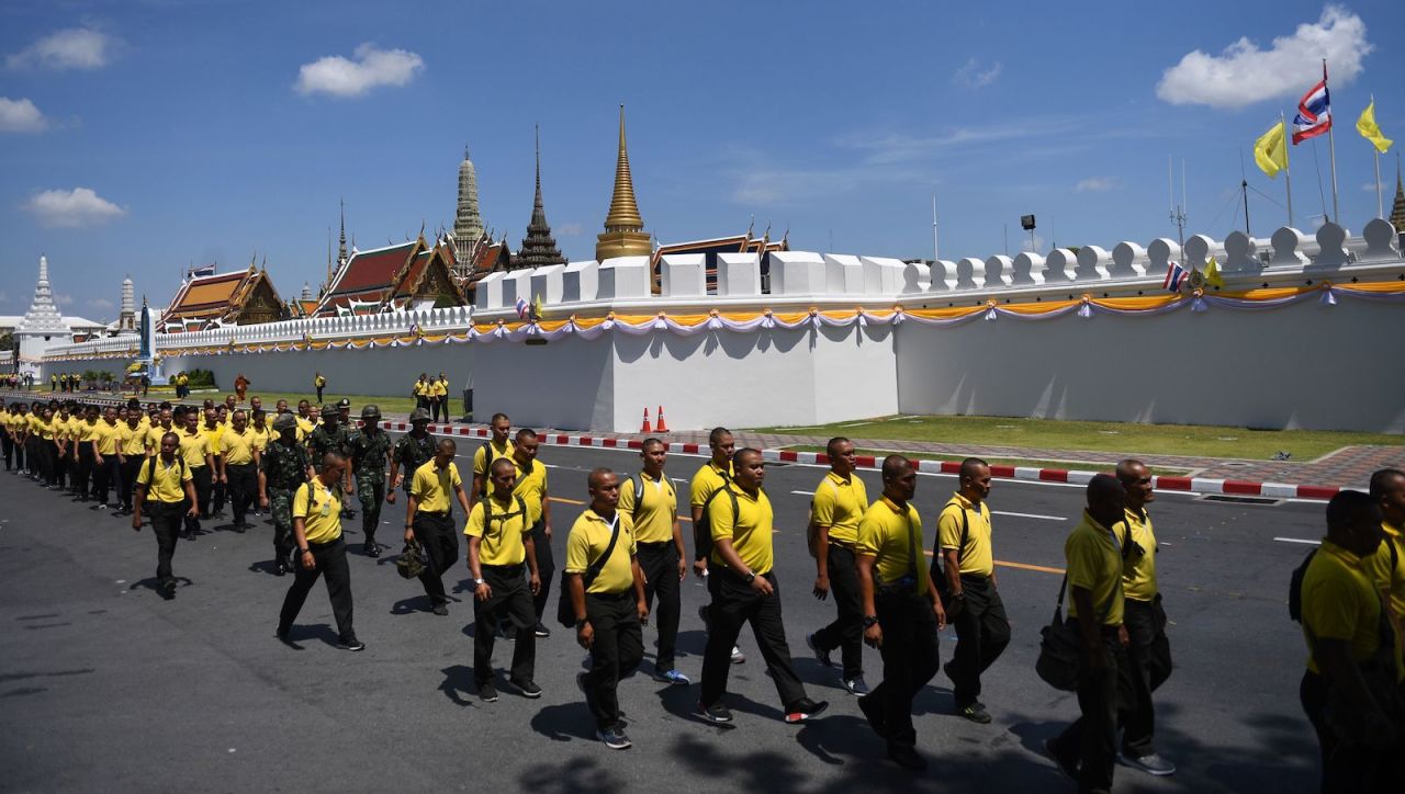 Volunteers walk in front of the Grand Palace before a rehearsal for the royal coronation of Thailand's King Maha Vajiralongkorn.