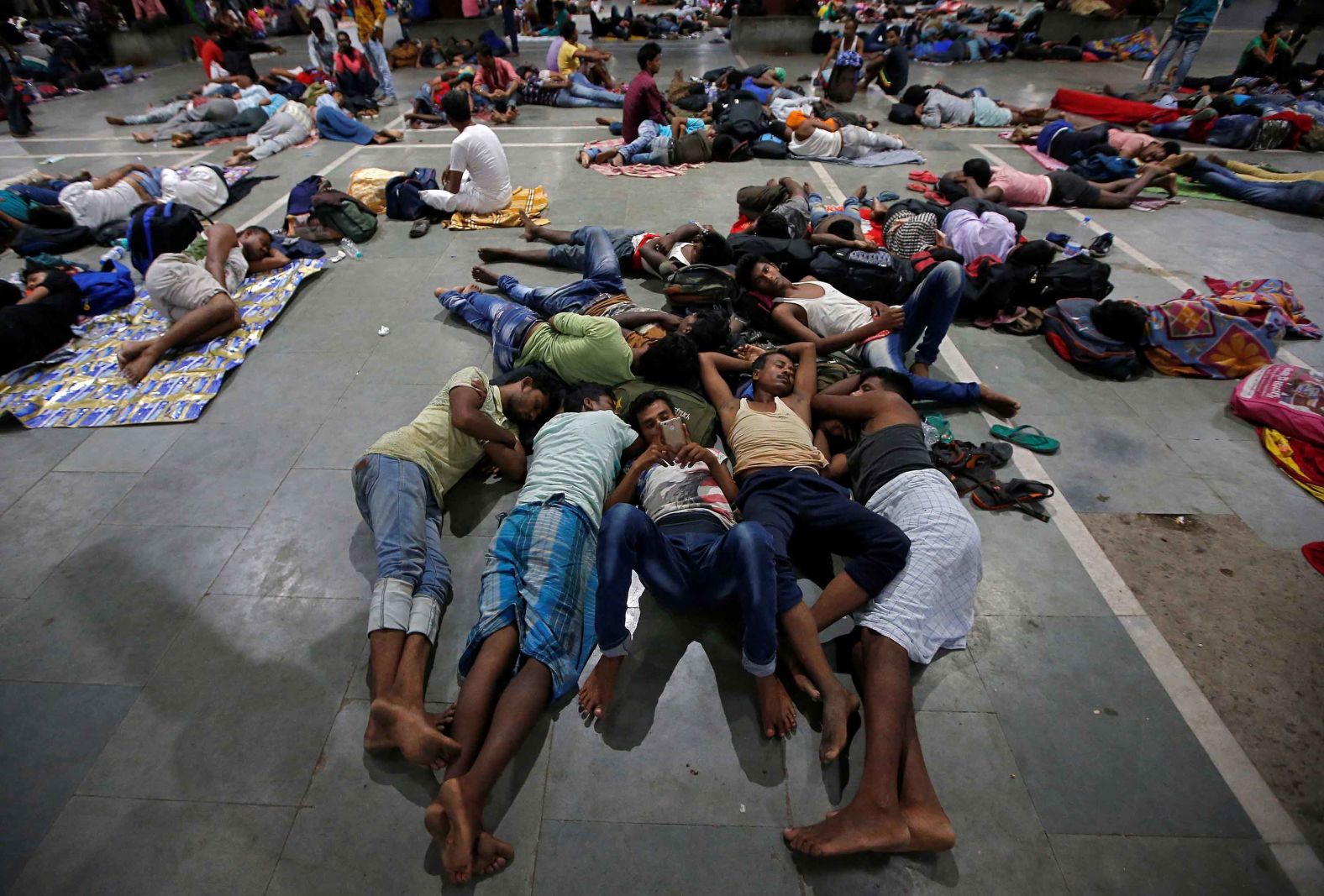 Stranded passengers rest inside a railway station in Kolkata after trains were canceled ahead of the storm.