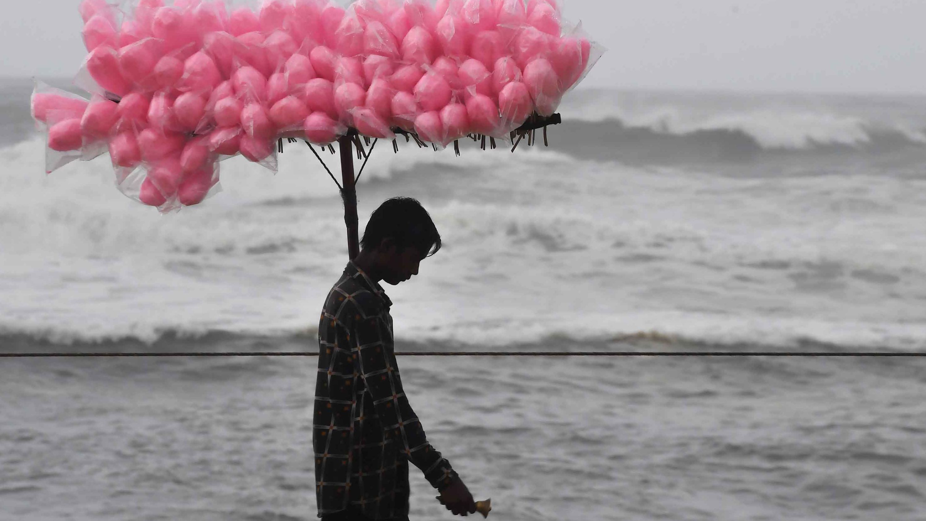 A candy vendor walks along a closed beach in Puri on May 2.