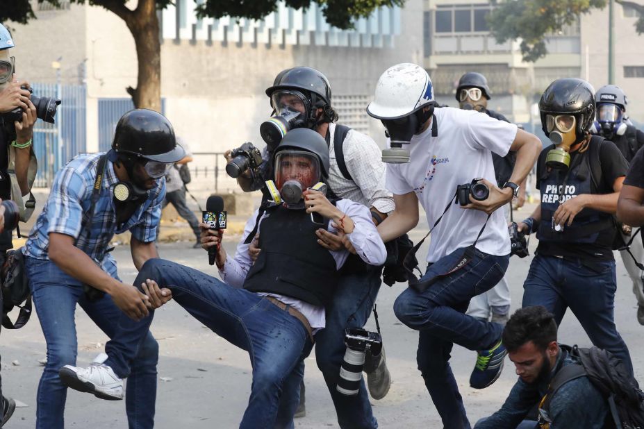 Journalists carry reporter Gregory Jaimes, who was injured Wednesday, May 1, while covering clashes between security forces and anti-government protesters in Caracas.
