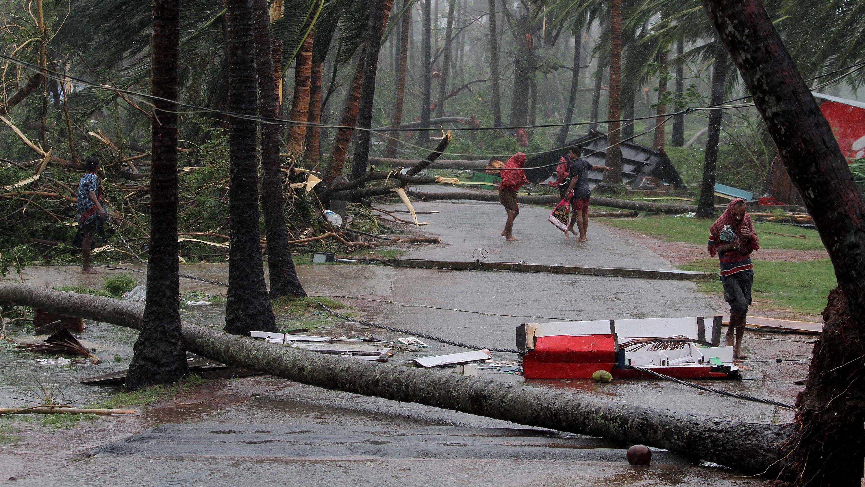 People run for shelter after Tropical Cyclone Fani made landfall near Puri, India, on Friday, May 3.